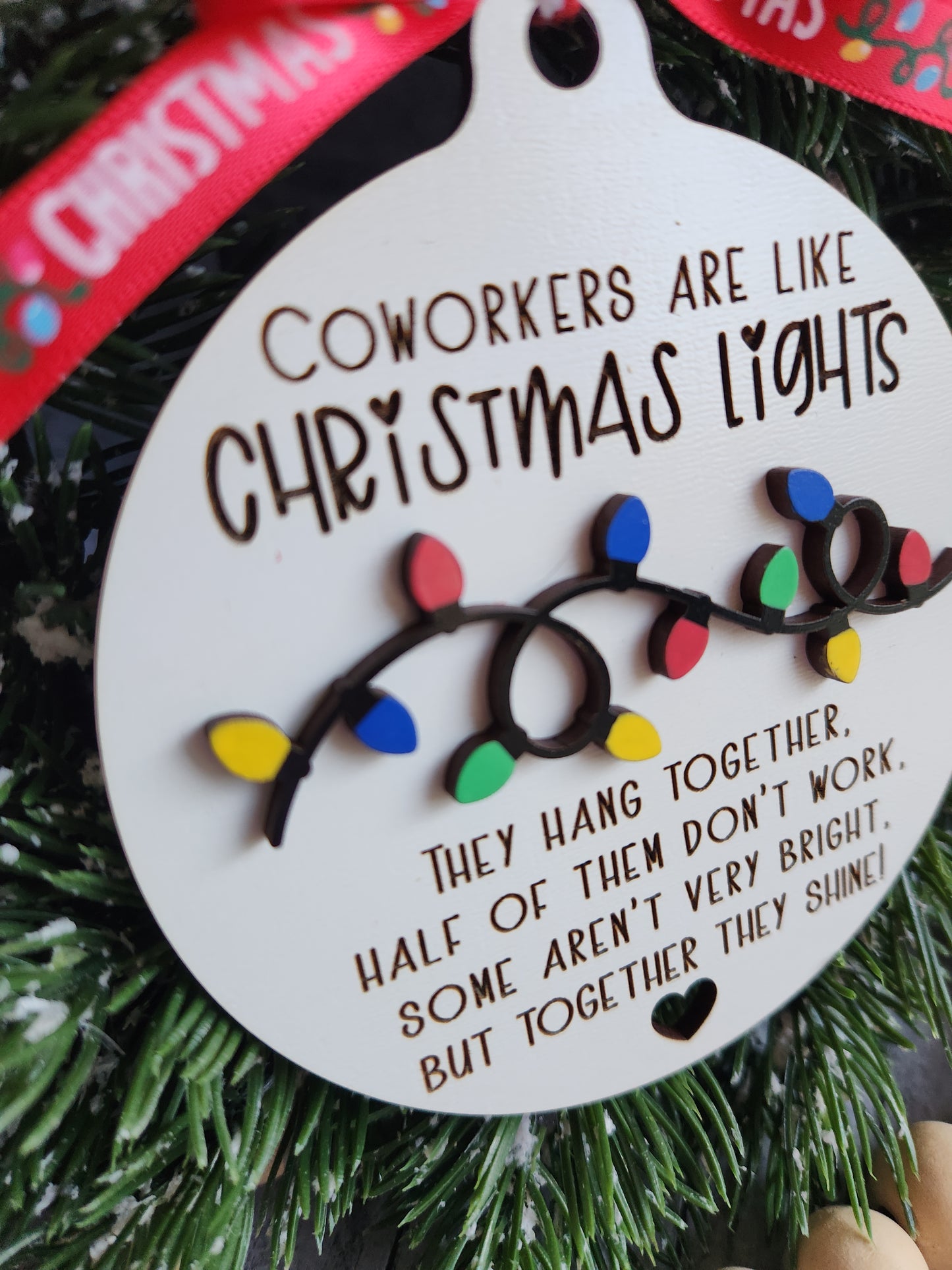 Decorative ornament with Christmas lights and text on a green wreath