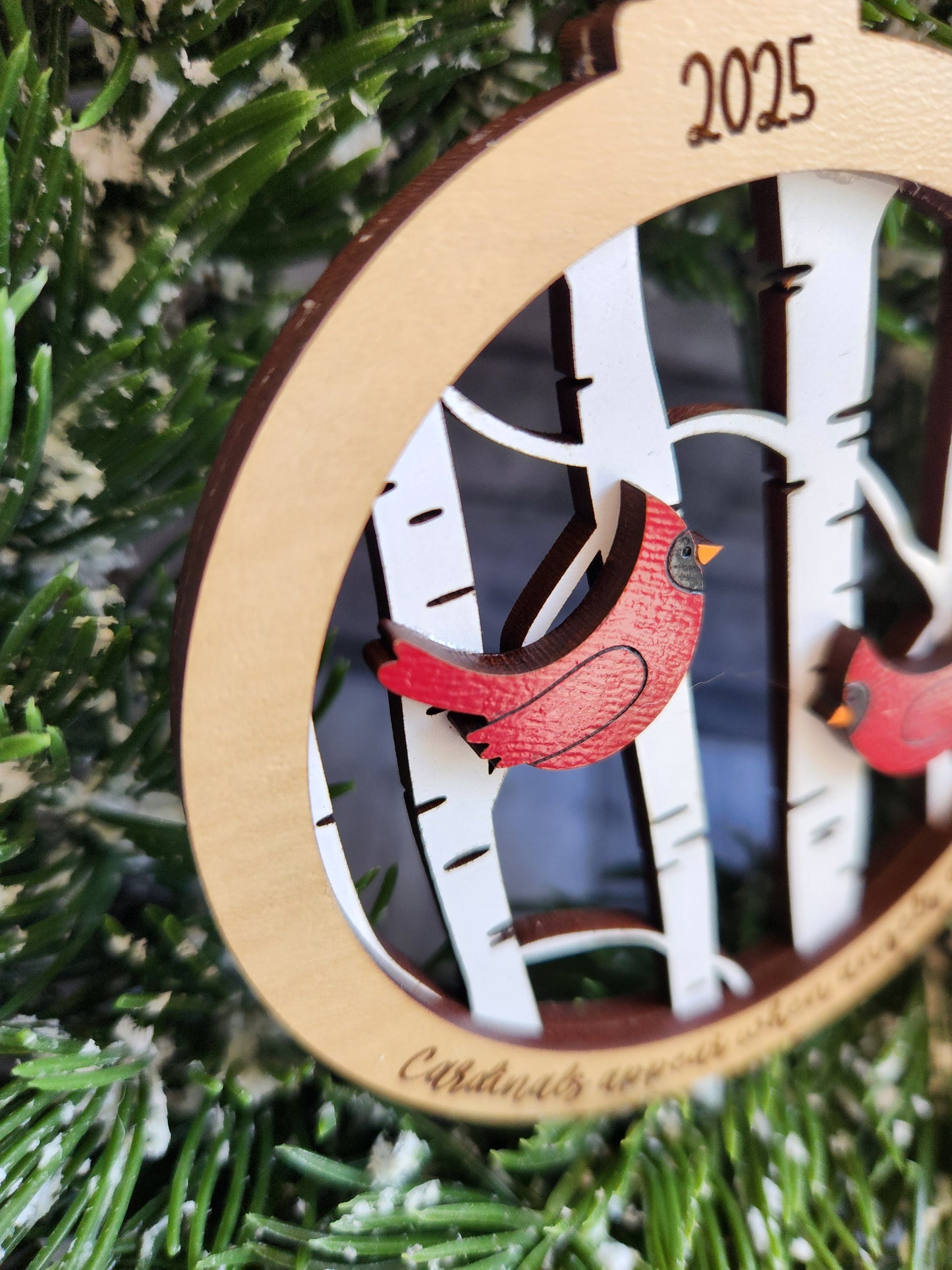 Wooden ornament with a red bird design on a Christmas tree
