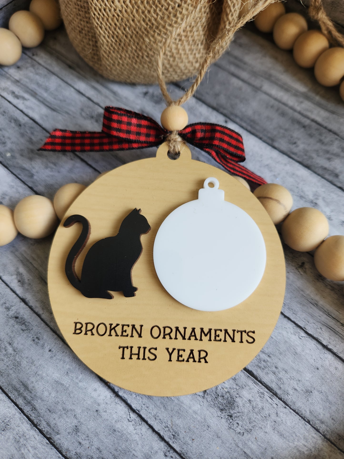 Decorative ornament with a cat silhouette and text on a wooden surface