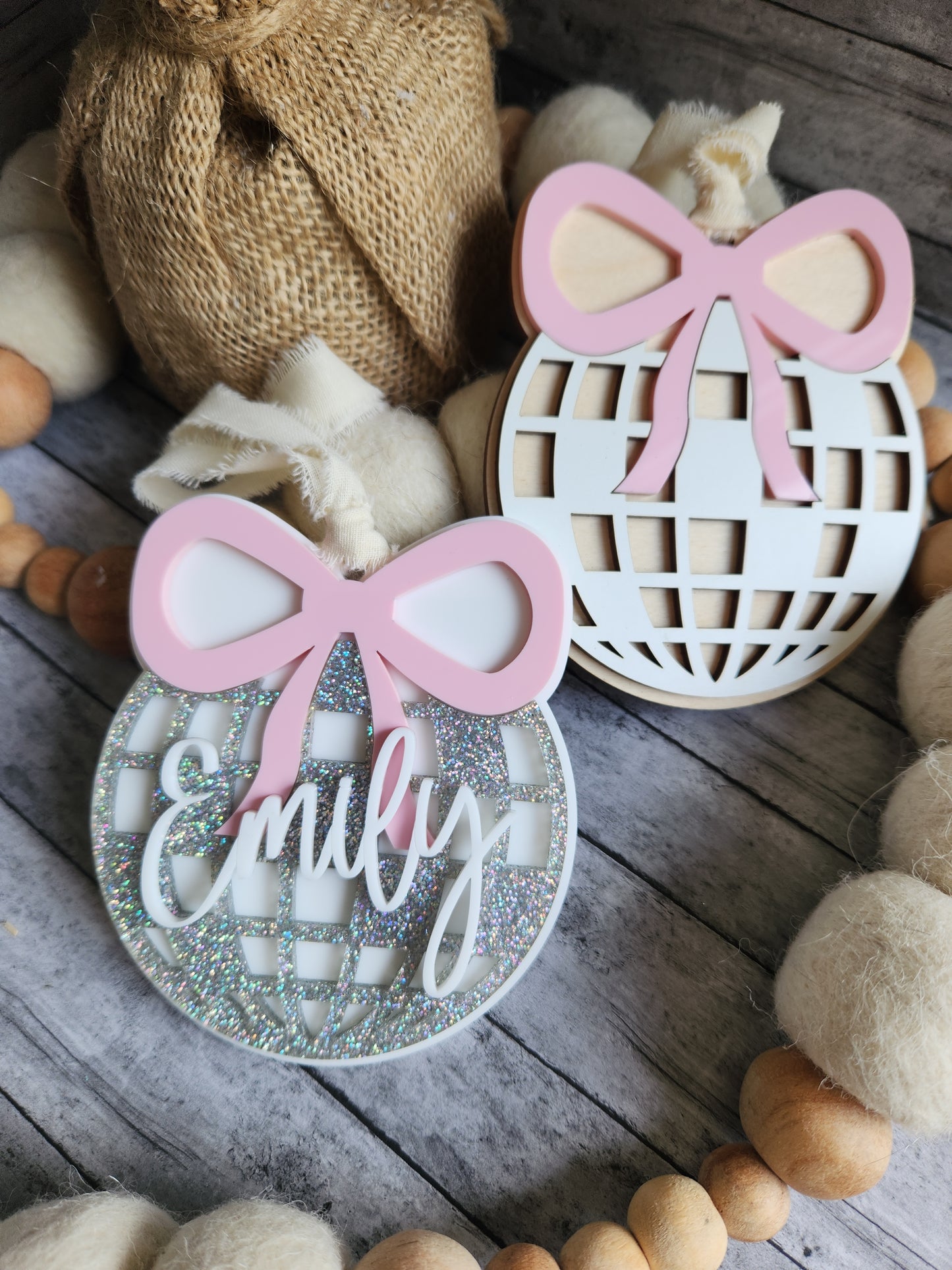Decorative cutouts with pink bows and text on a wooden surface