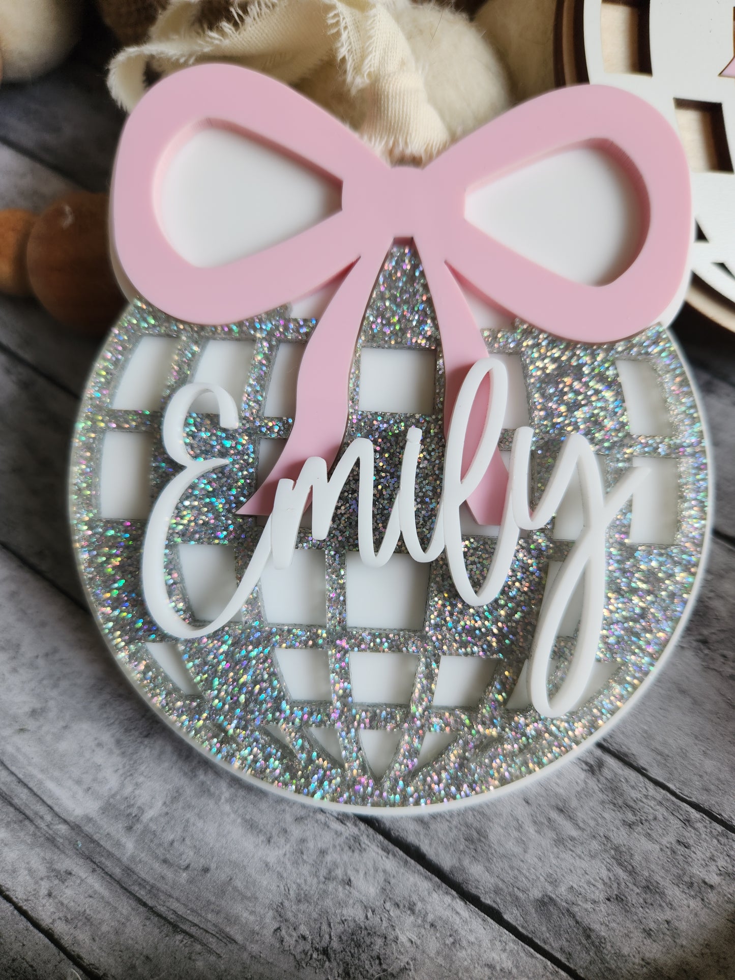 Decorative item with pink bow and 'Mum' text on a wooden surface