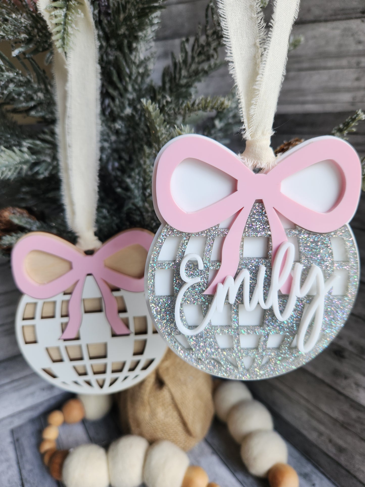 Decorative item with pink ribbons and 'family' text on a wooden surface.