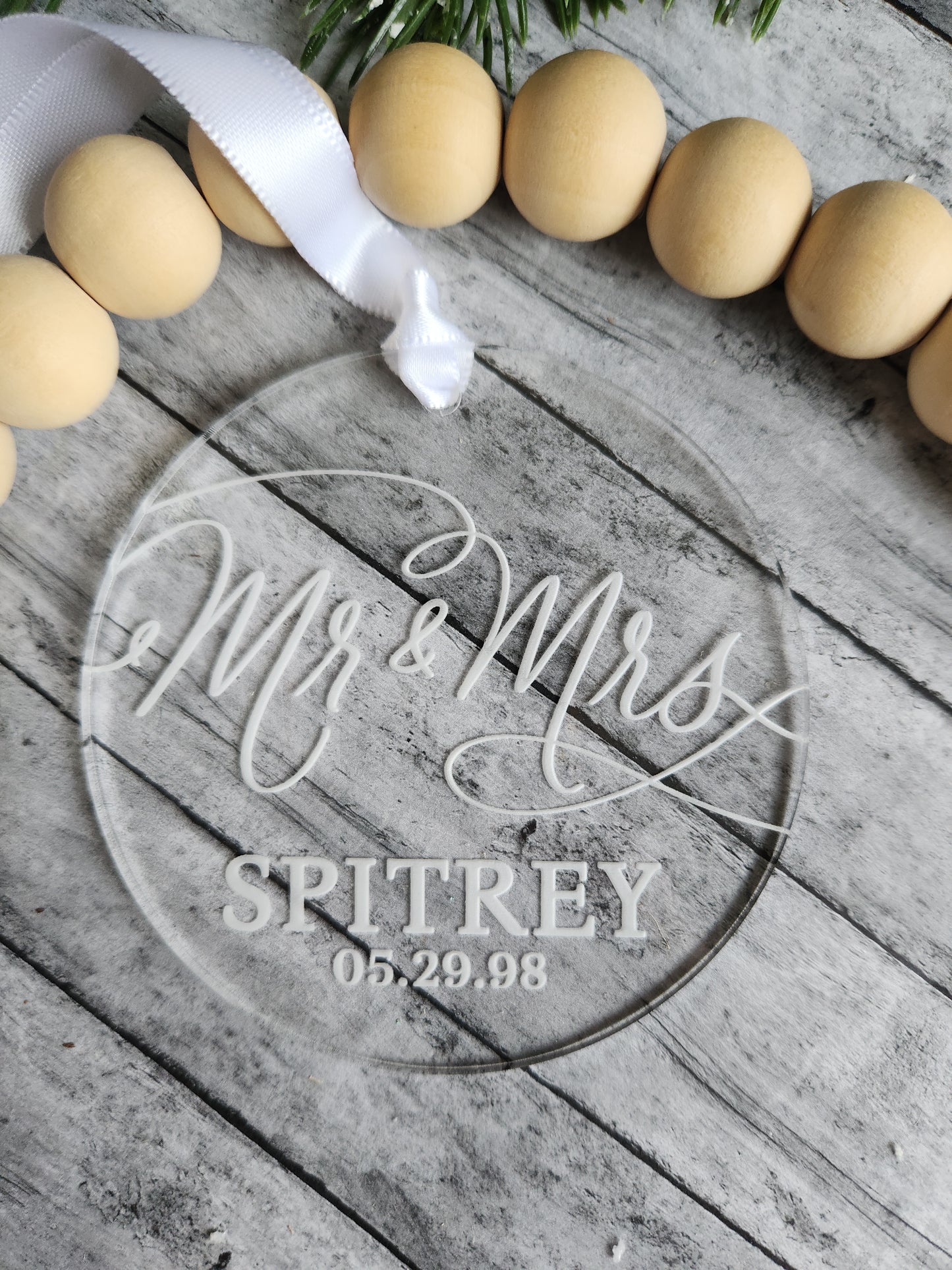 Decorative sign with 'Mr & Mrs' and personalized text on a wooden surface with eggs and ribbon.