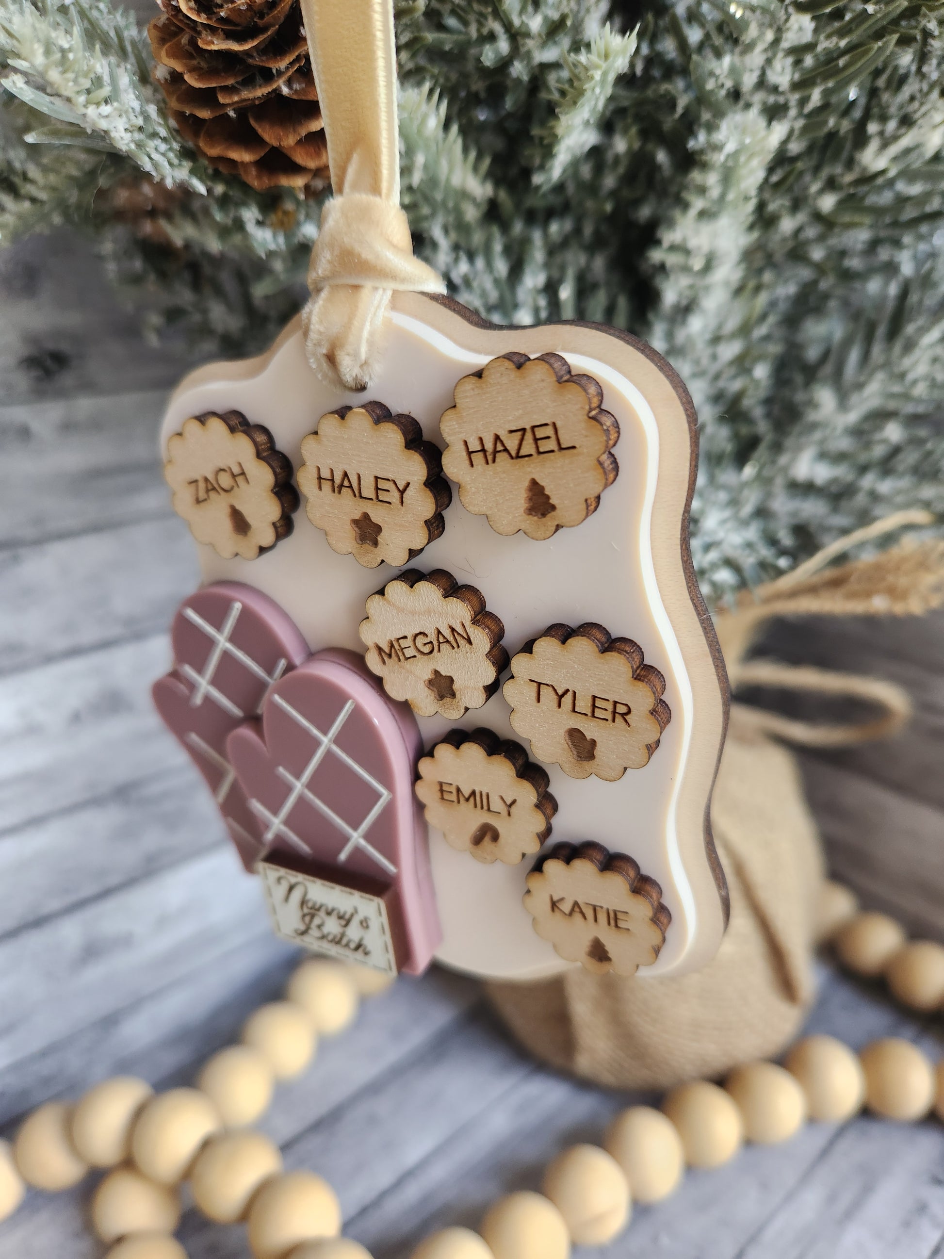 Decorative headband with wooden name tags and a gingerbread house charm, set against a Christmas tree background.