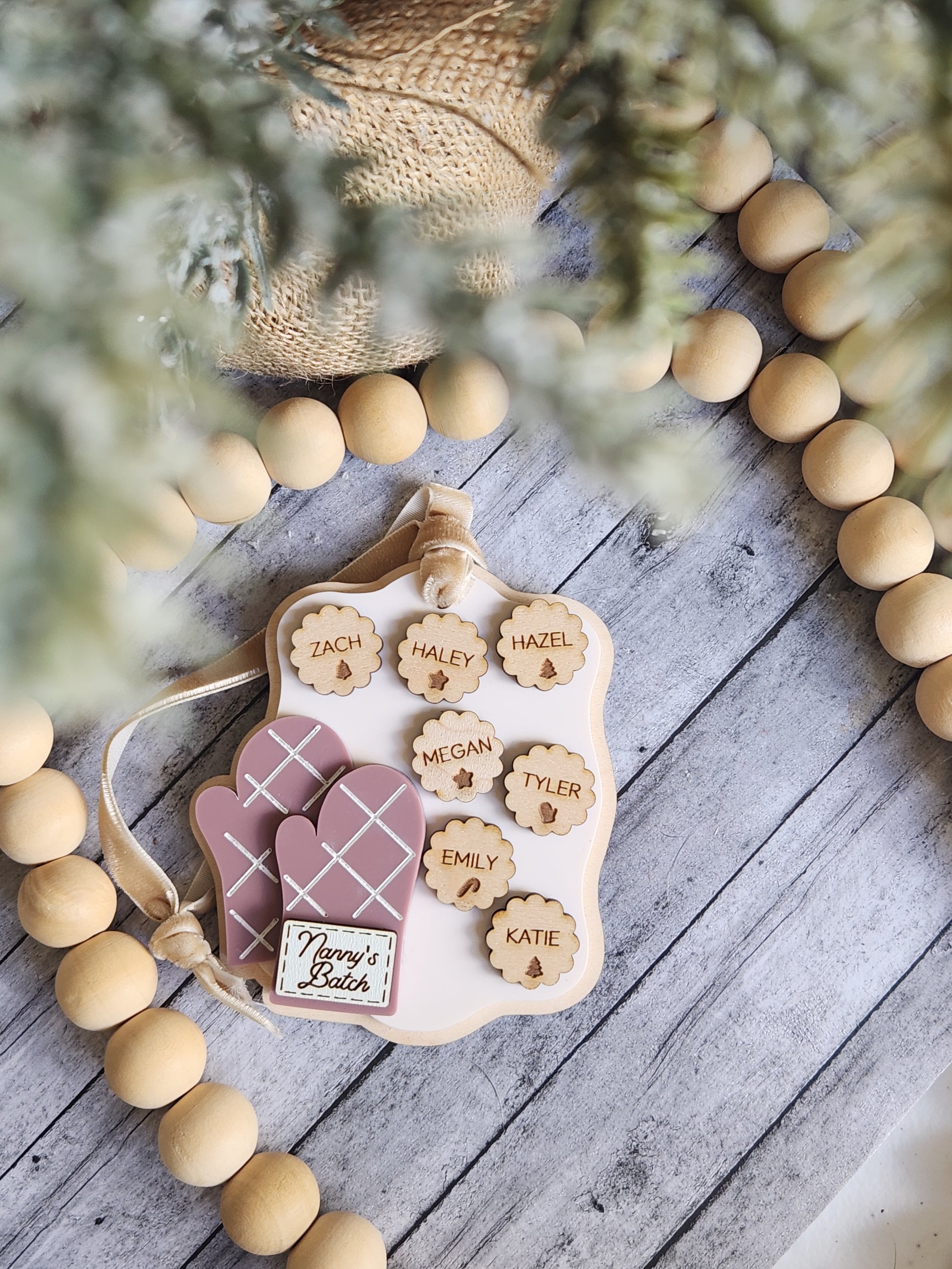 Wooden name board with wooden letters and a pink heart on a wooden surface with decorative elements.