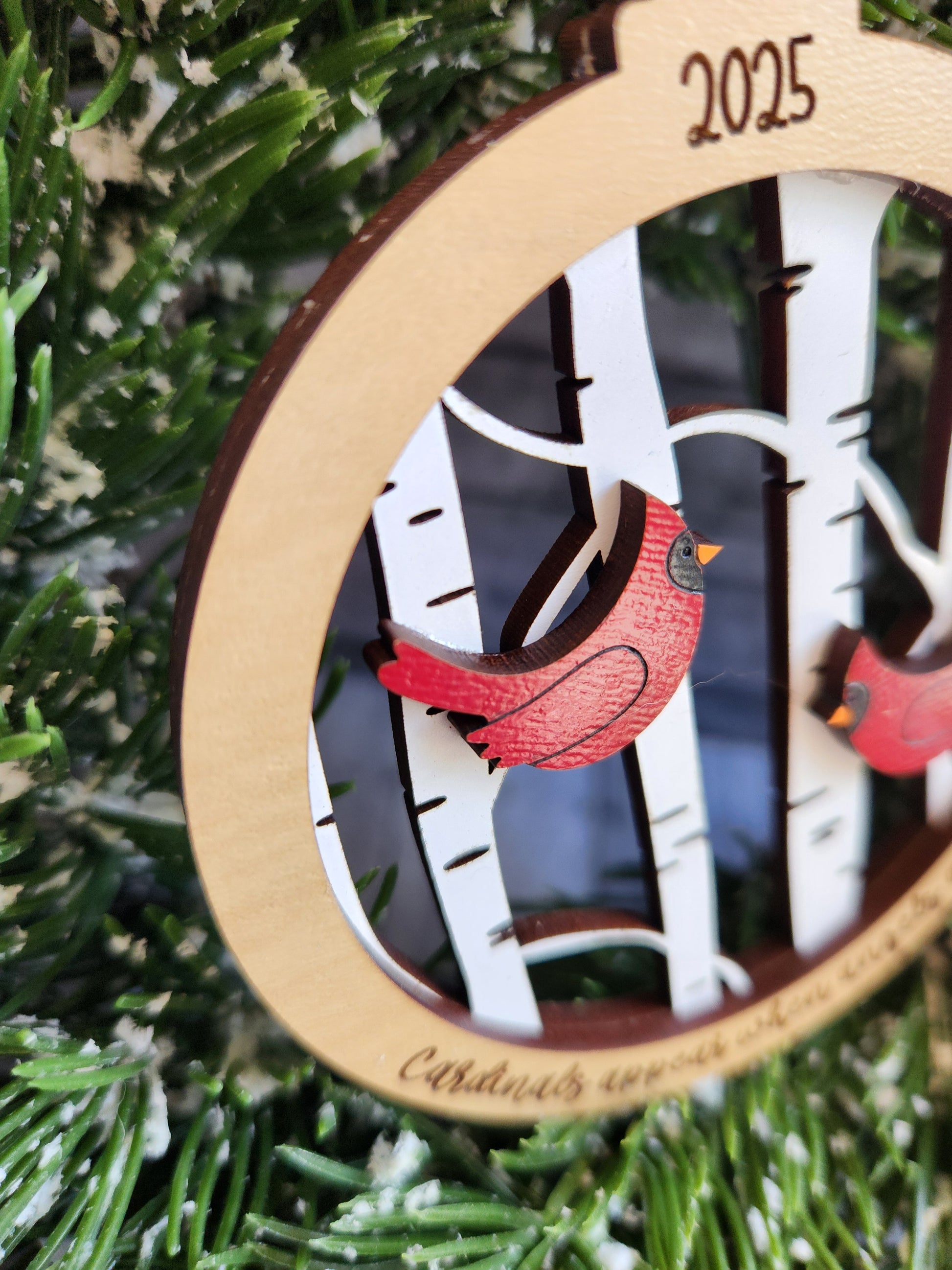Wooden ornament with a red bird design on a Christmas tree