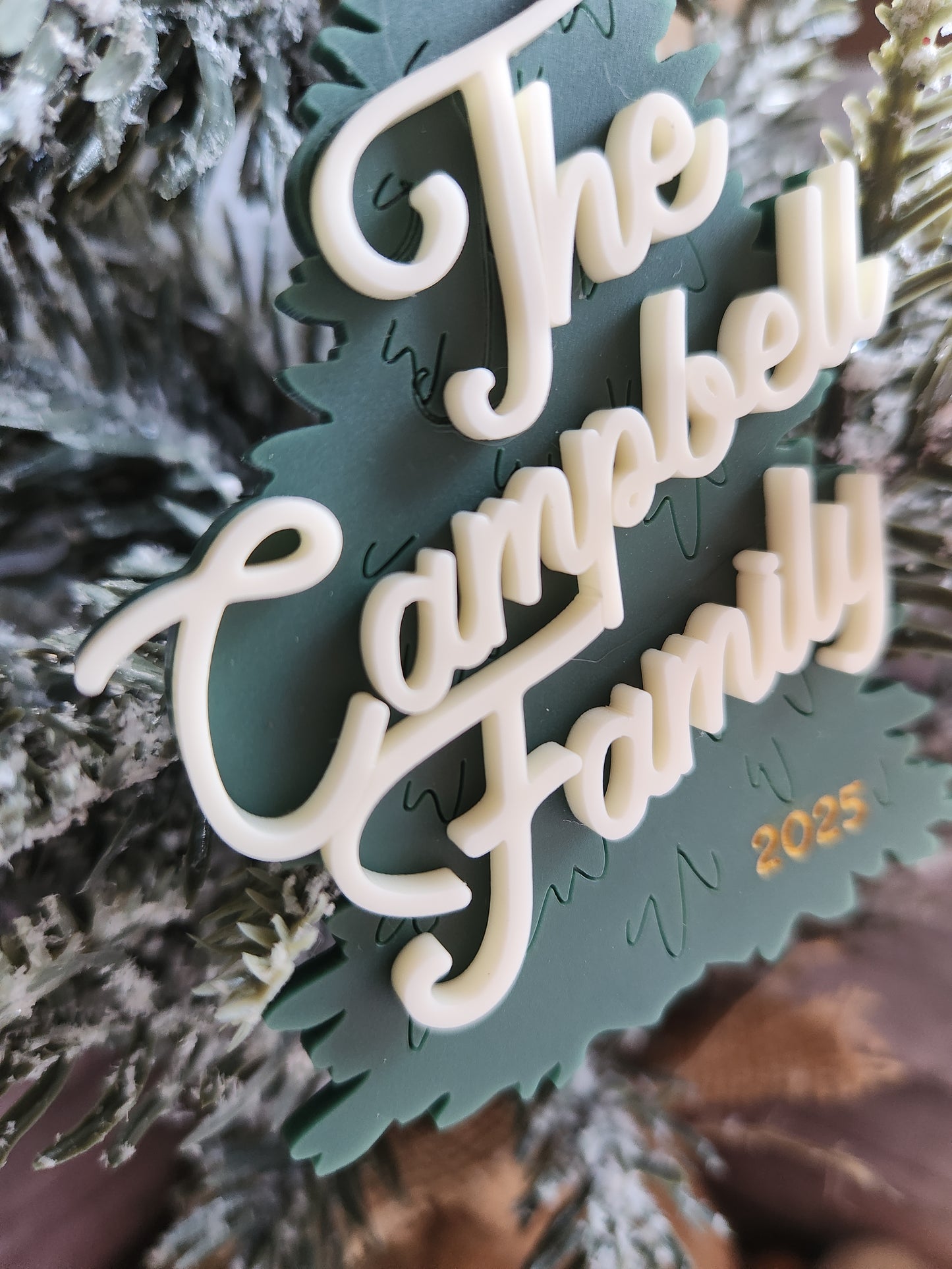 Decorative green and white ornament with 'Happy Holidays' text on a tree.