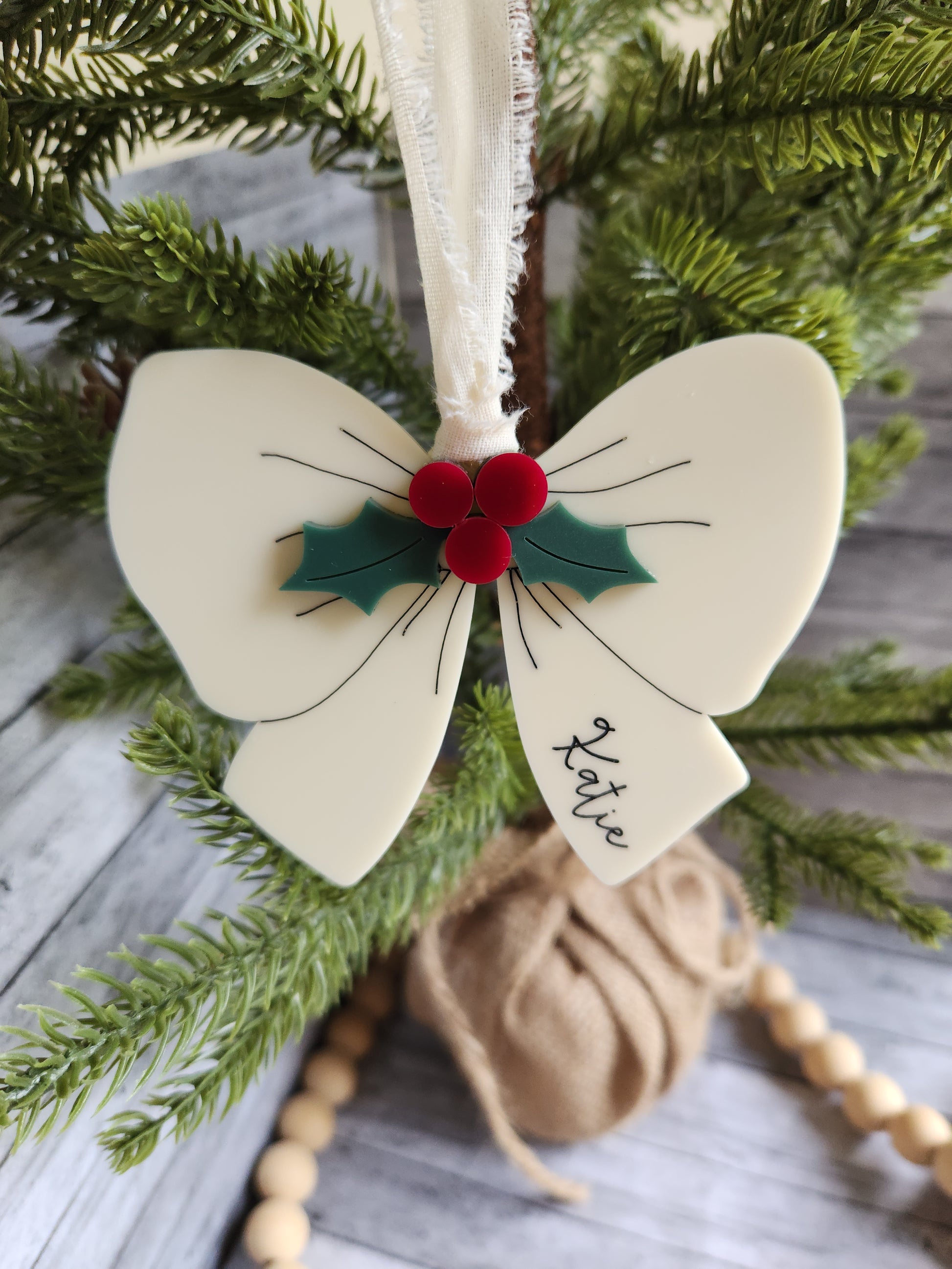 Decorative headband with floral design and 'Katie' inscription on a green leafy background