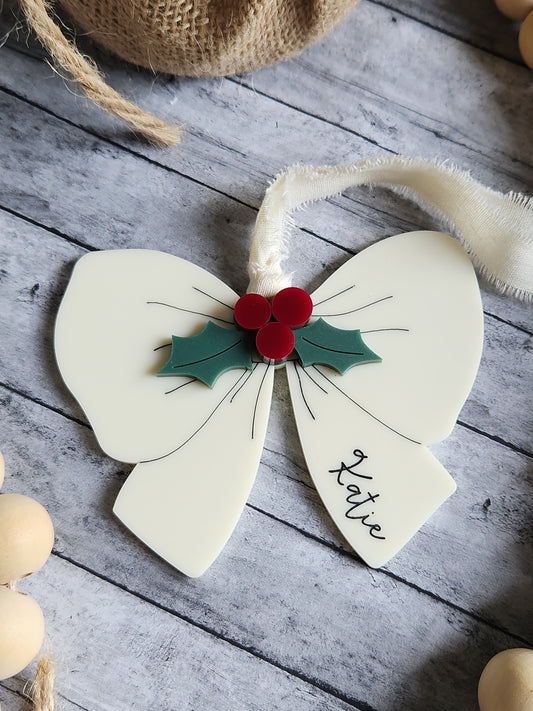 Decorative flower-shaped card with holly design and 'Katie' inscription on a wooden surface.