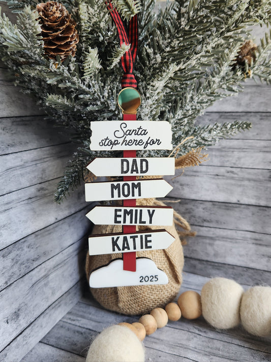 Decorative name tags on a Christmas wreath with pine cones and wooden beads.