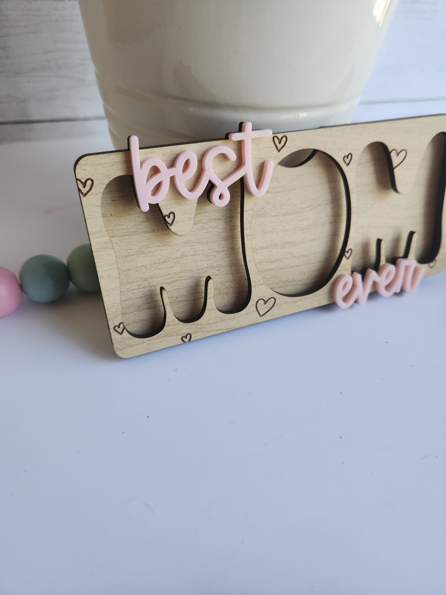 Wooden coaster with 'Happy' and heart designs on a light surface