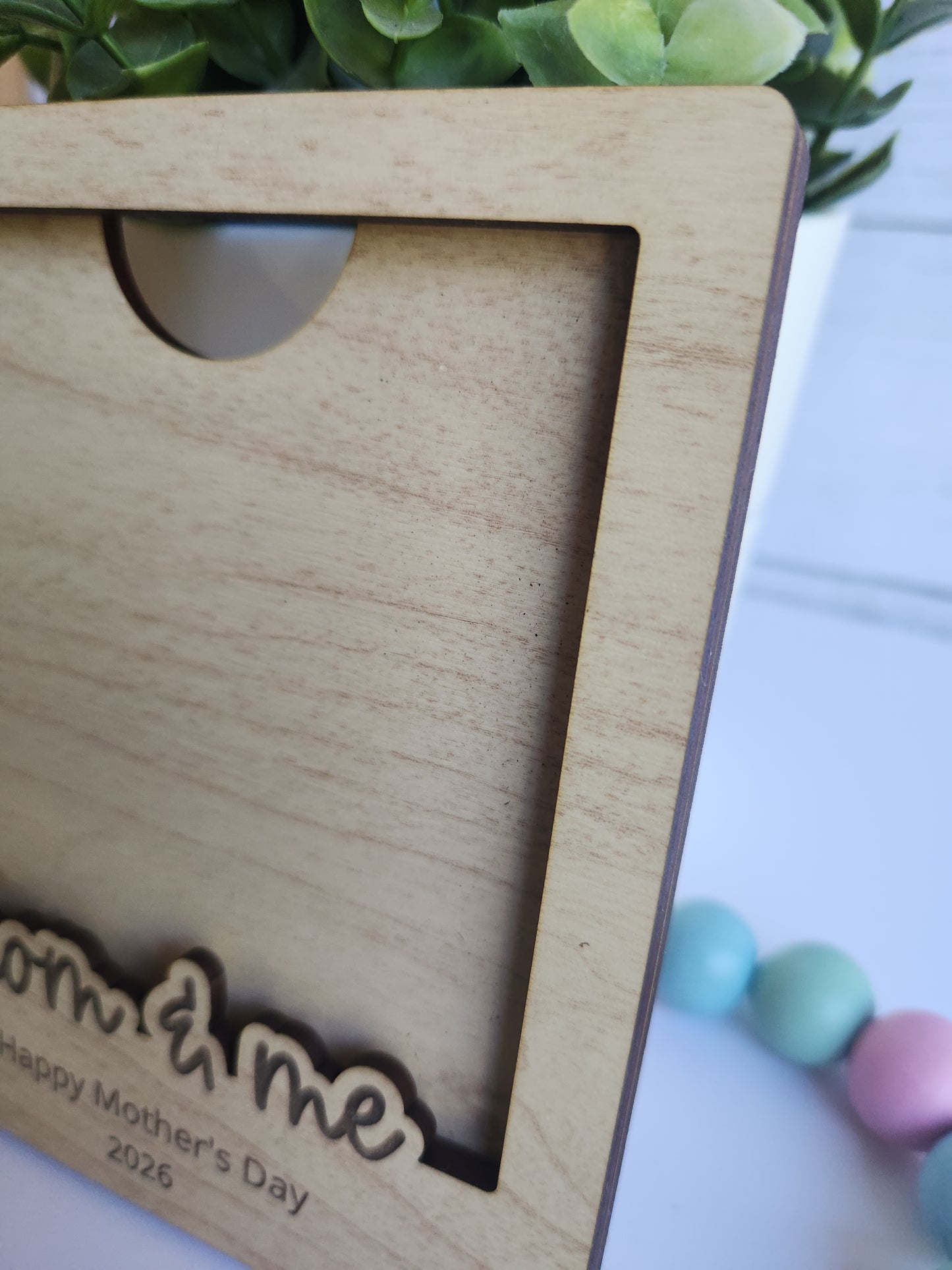 Wooden photo frame with 'Mom & Me' engraving on a light background