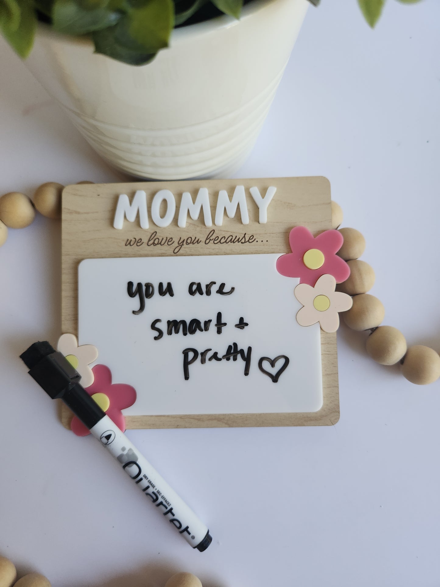 Personalized wooden dry erase message board for mom with floral accents, engraved with “Mommy we love you because,” custom Mother’s Day gift from kids displayed with greenery and neutral home decor styling.