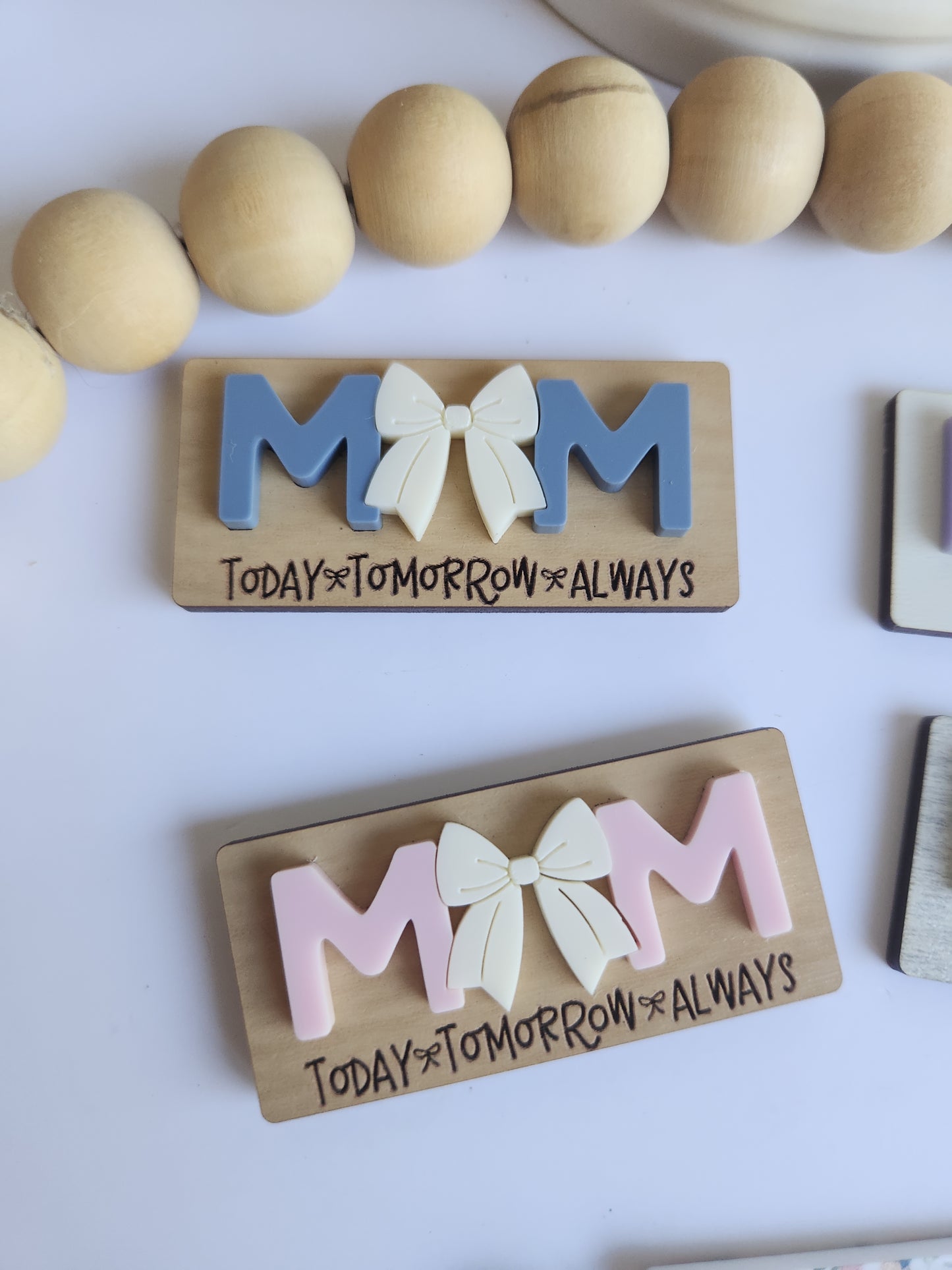 Wooden nameplates with decorative letters on a white surface
